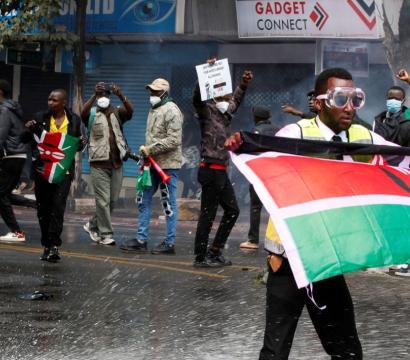 L'image montre des manifestants arborant le drapeau kényan lors des manifestations de la « Génération Z »