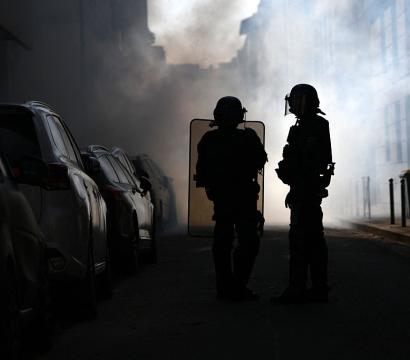 Riot police stand amid tear gas smoke during clashes with protesters on the sidelines of a demonstration of high-school students as part of a nationwide protest movement over learning conditions in Lyon, on October 6, 2026.